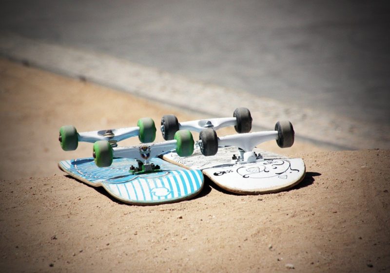 Two skateboards sitting on the ground.