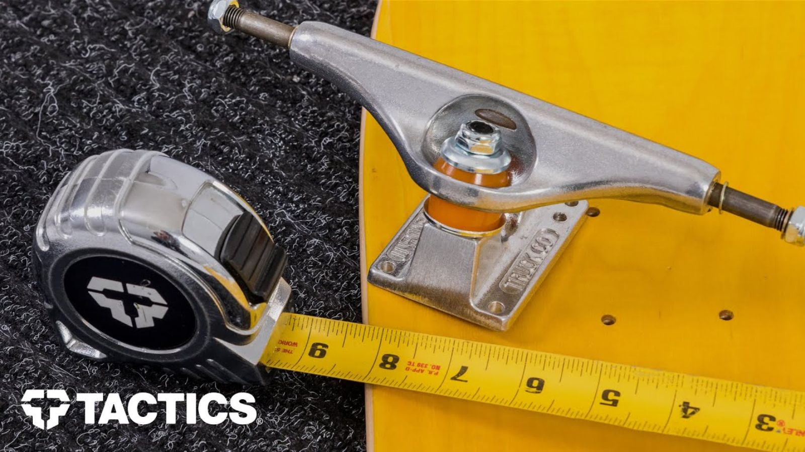 A measuring tape next to a skateboard.